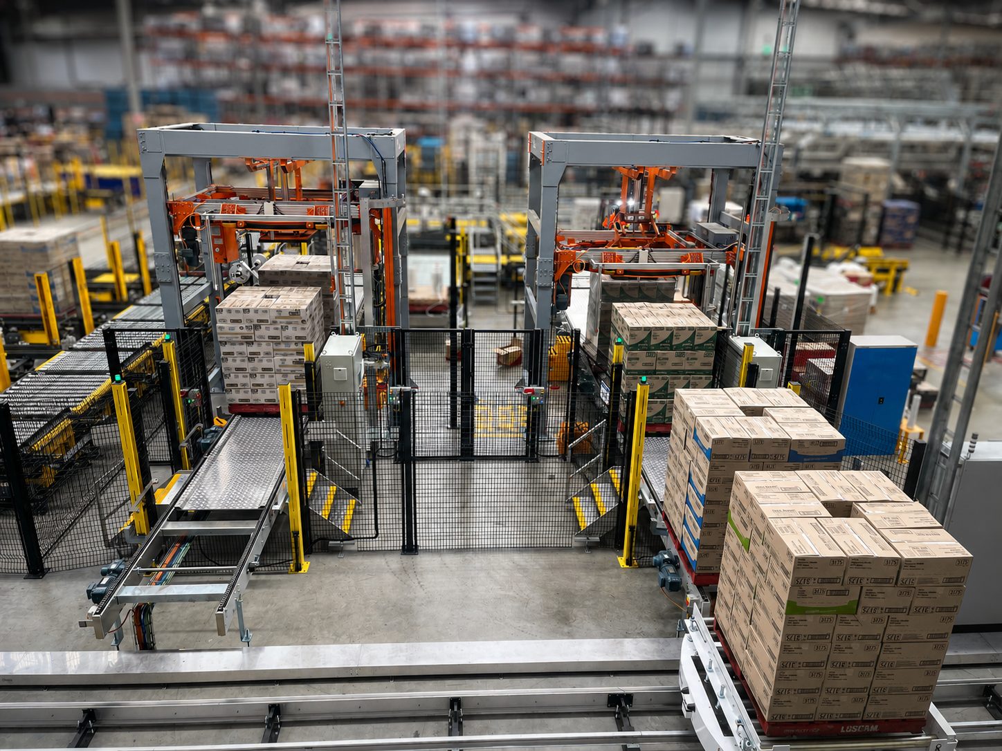 Two automatic ring wrappers running in line, with wrapped pallets of cartons leaving on the outfeed conveyor
